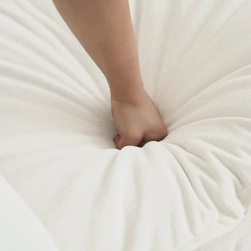 Sillón de chenilla blanco con asiento profundo y cojín decorativo